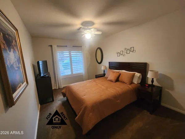 a bedroom with a bed and a flat tv screen on the dresser