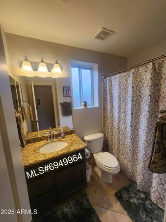 a bathroom with a granite countertop sink a toilet and bathtub