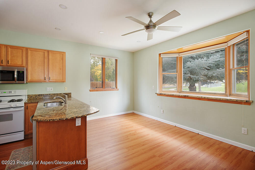 330 Alexander Lane Basalt, CO 81621 - Photo 2 of 10 a kitchen with stainless steel appliances granite countertop wooden cabinets a stove a sink a island and a window