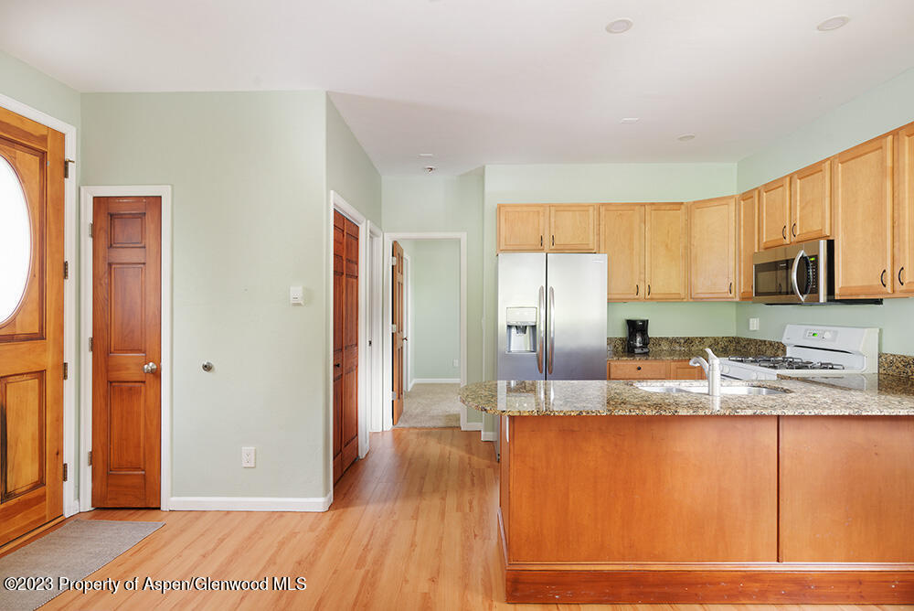 330 Alexander Lane Basalt, CO 81621 - Photo 7 of 10 a kitchen with stainless steel appliances granite countertop a refrigerator a stove and a sink with wooden floor
