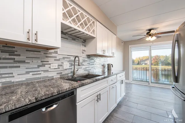 a kitchen with stainless steel appliances granite countertop a sink a stove and cabinets