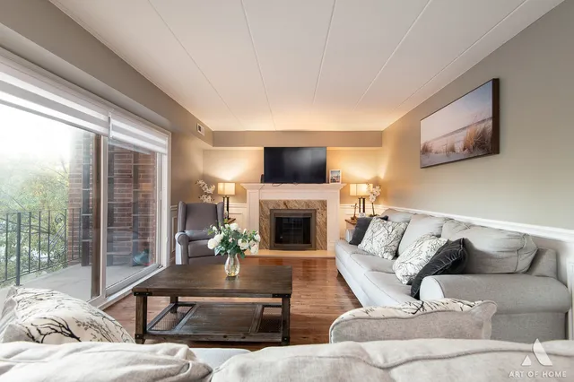 a living room with furniture fireplace and a large window