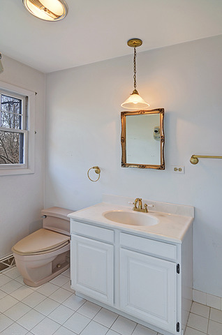 851 South County Line Road Hinsdale, IL 60521 - Photo 17 of 25 a bathroom with a toilet a sink and mirror