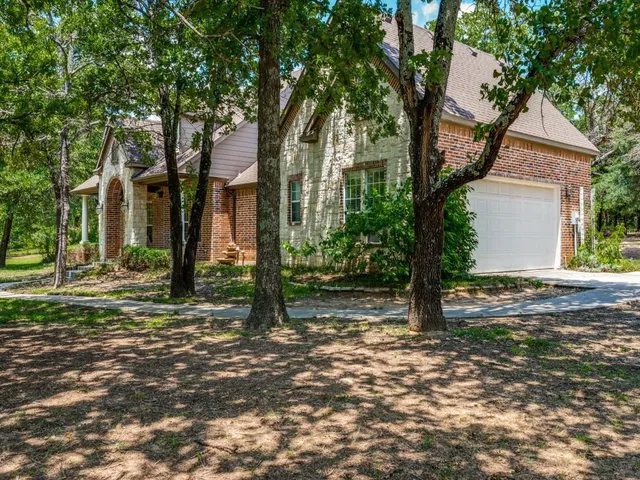 a view of a house with a tree in front