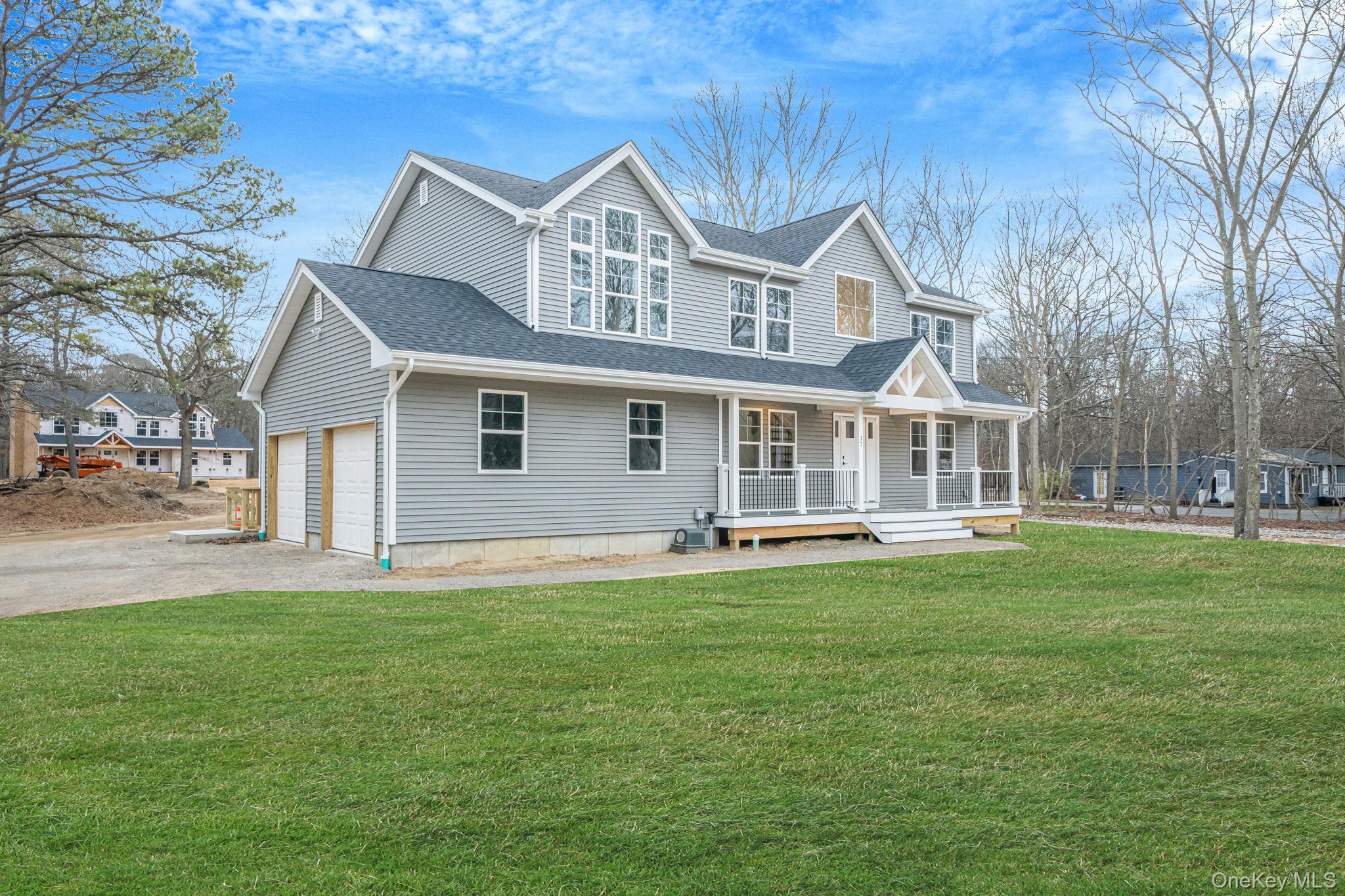 a front view of a house with a garden and trees