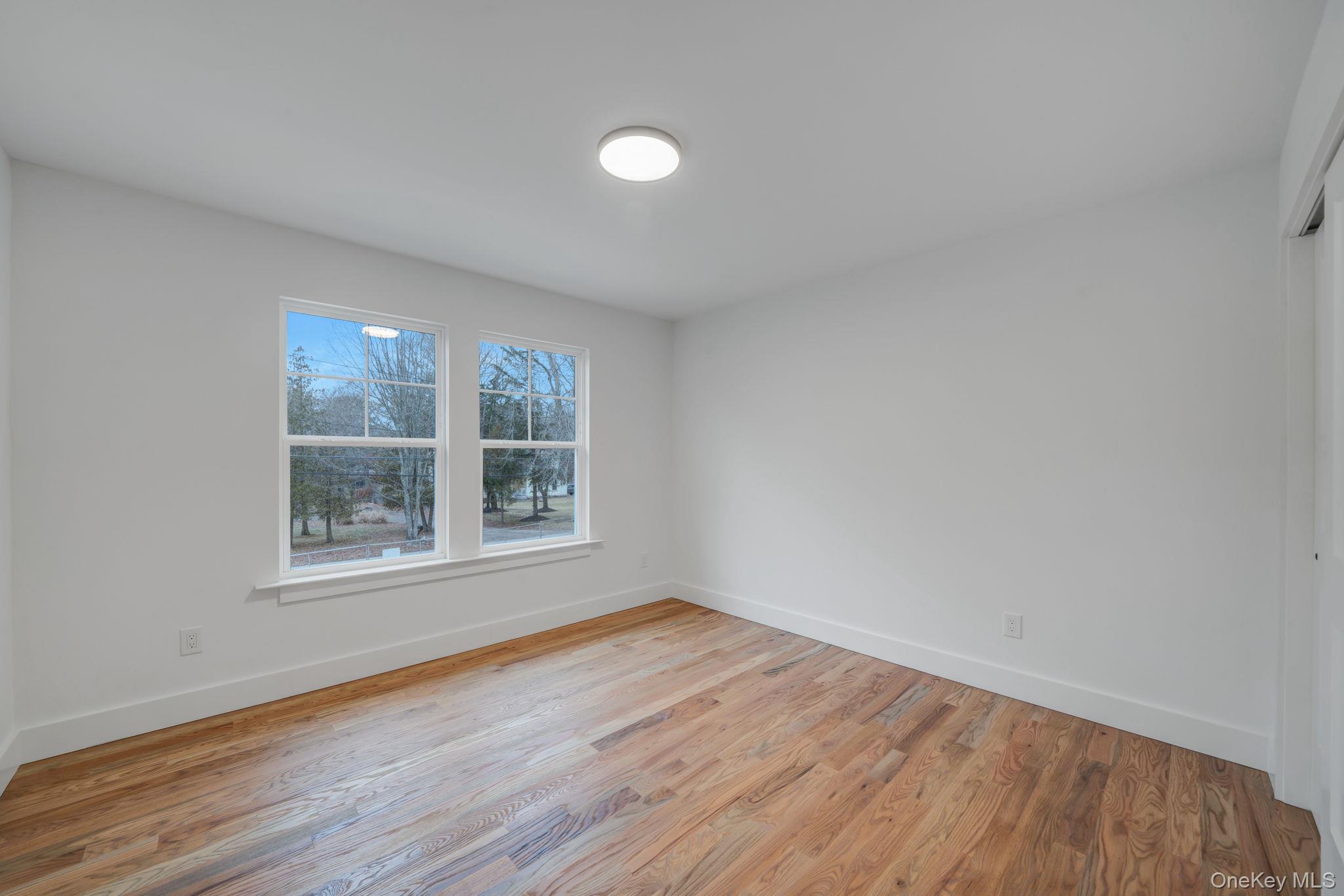 63 A Blydenburgh Road Centereach, NY 11720 - Photo 23 of 38 a view of an empty room with wooden floor and a window