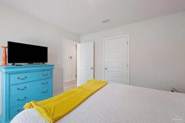 a bedroom with a bed and flat screen tv