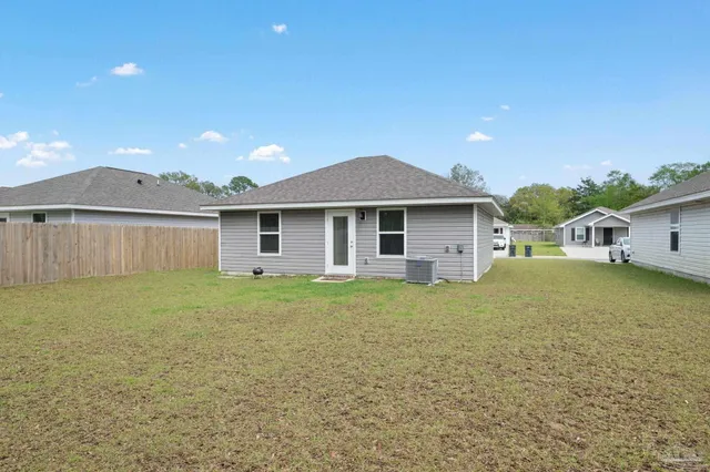 a view of a house with a yard and a large tree