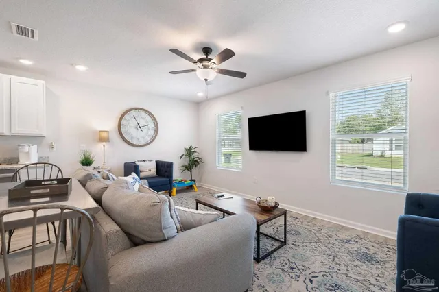 a living room with furniture a window and a flat screen tv