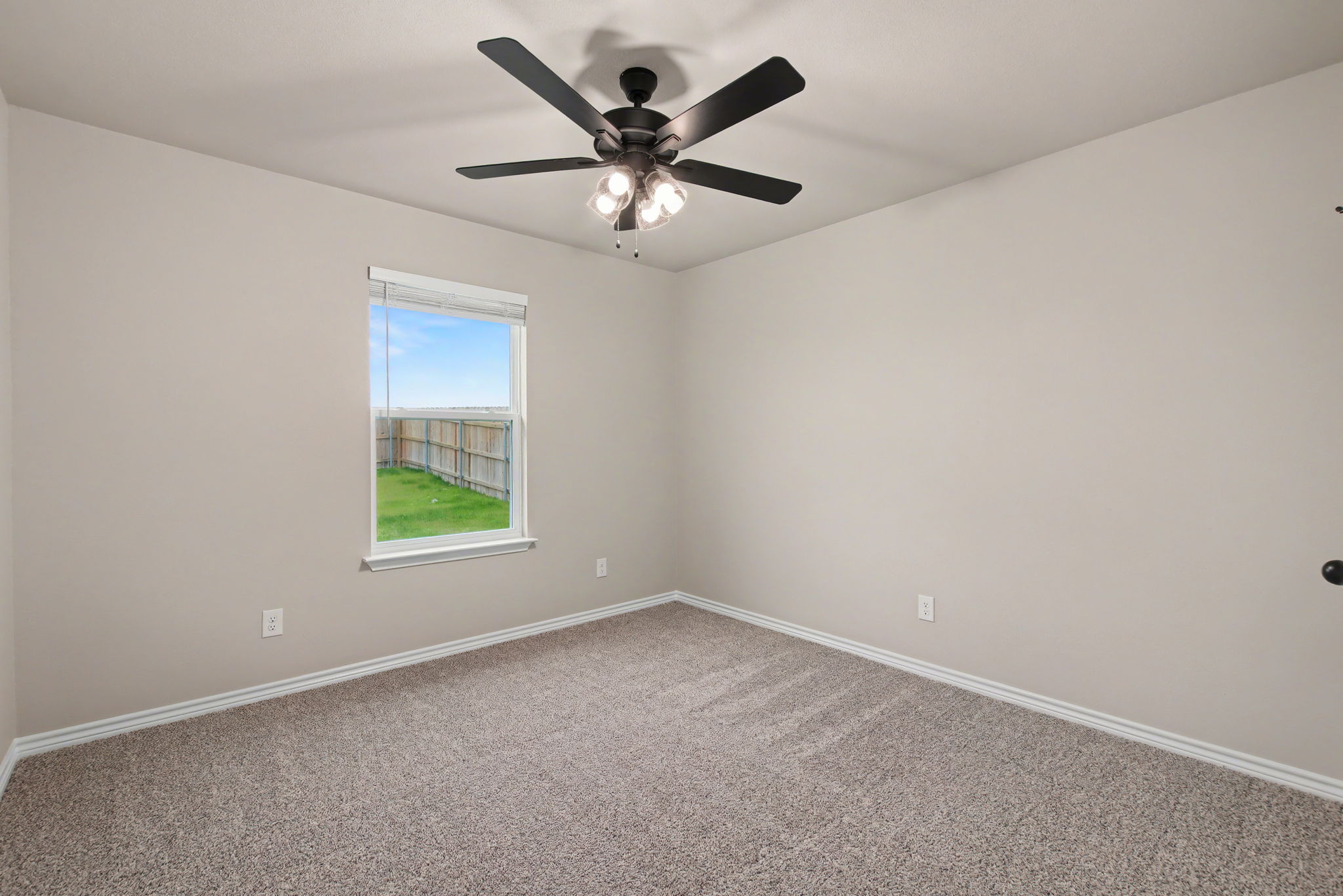 206 Water Wl Road Burnet, TX 78611 - Photo 15 of 25 Plush carpet flooring and a large window framing backyard views define this versatile secondary bedroom.