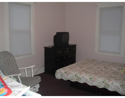 75 Redlands Street Springfield, MA 01104 - Photo 7 of 10 a bedroom with a bed and a chair