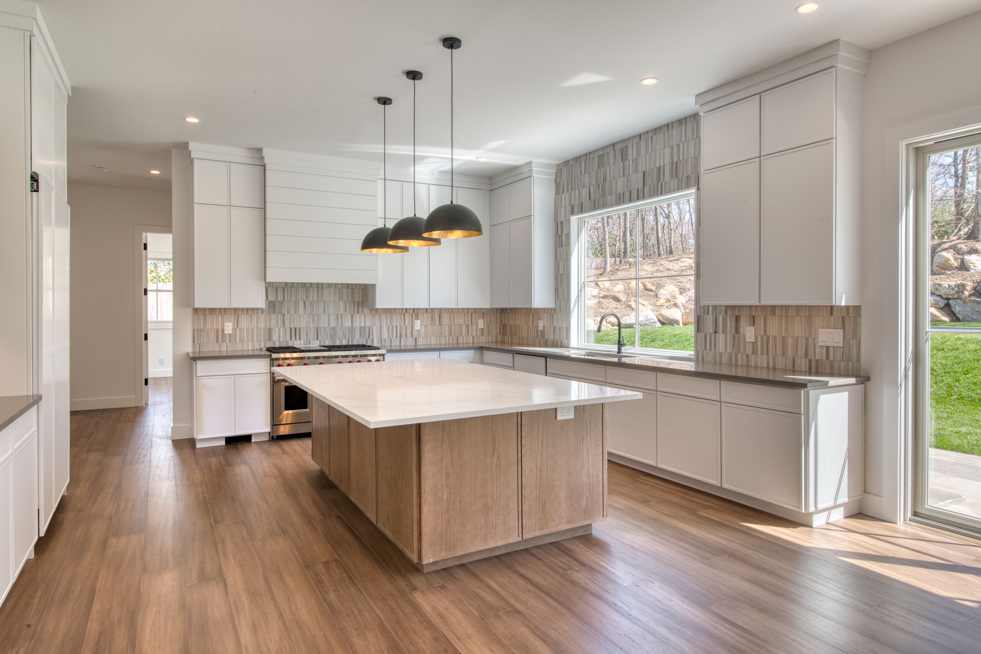 18 Barnes Avenue East Hampton, NY 11937 - Photo 6 of 35 a kitchen with stainless steel appliances granite countertop wooden floors sink and window