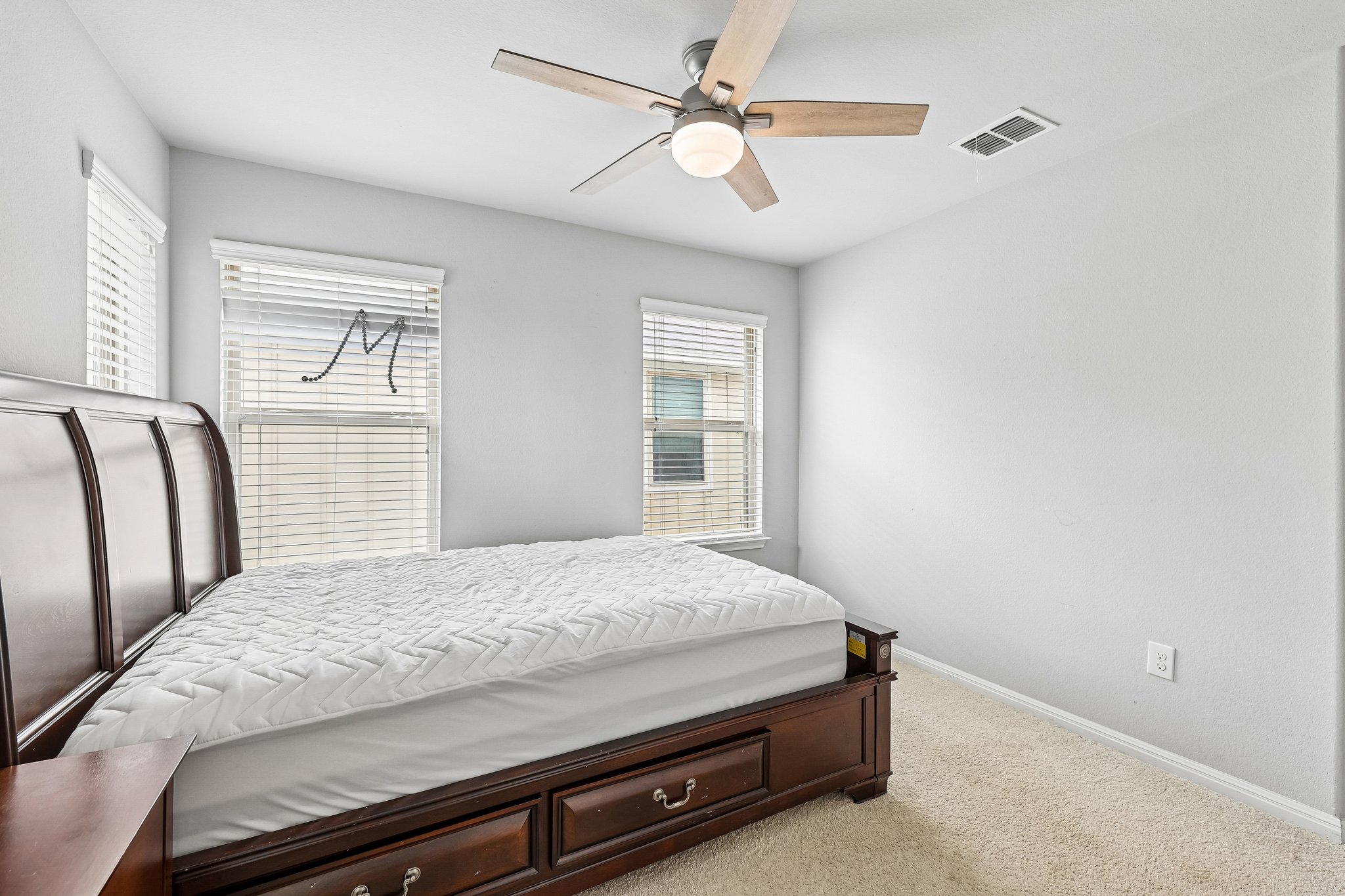 387 Guemal Road Buda, TX 78610 - Photo 25 of 39 Carpeted room featuring multiple windows with blinds, a ceiling fan with light fixture, and light-toned walls