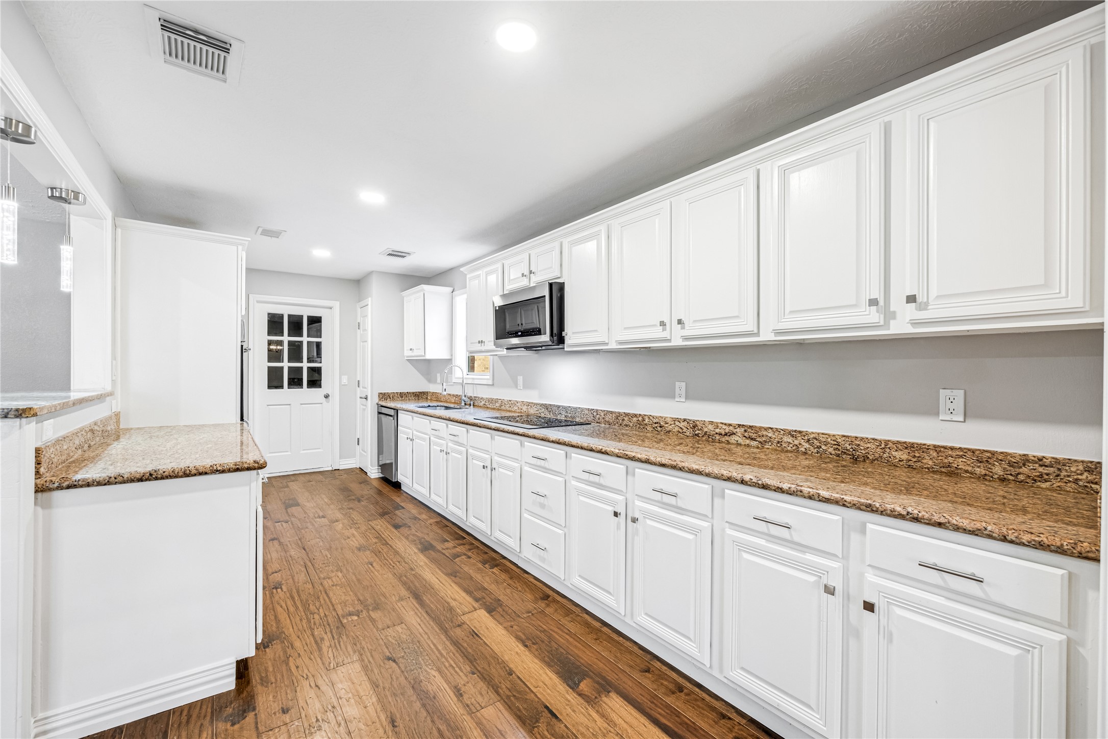 9806 Tanager Lane Conroe, TX 77385 - Photo 10 of 28 a kitchen with granite countertop a sink and cabinets