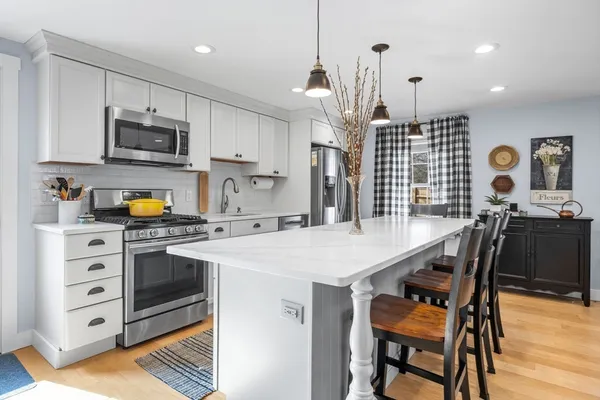 a kitchen with a sink a stove and chairs