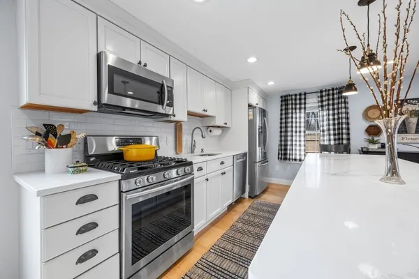 a kitchen with stainless steel appliances granite countertop a stove a sink and a microwave