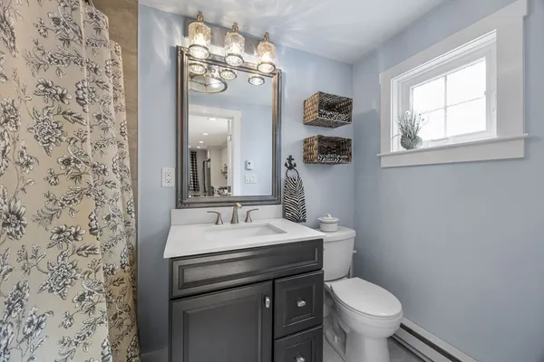 a bathroom with a toilet a sink and mirror