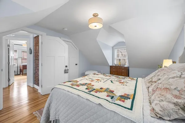 a bedroom with bed and wooden floor
