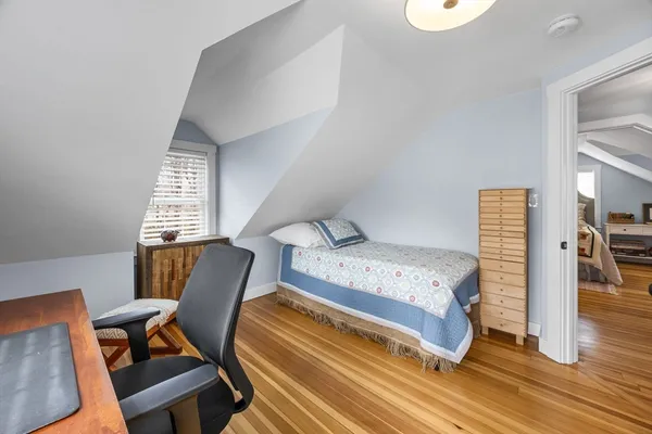 a view of a bedroom with workspace and windows