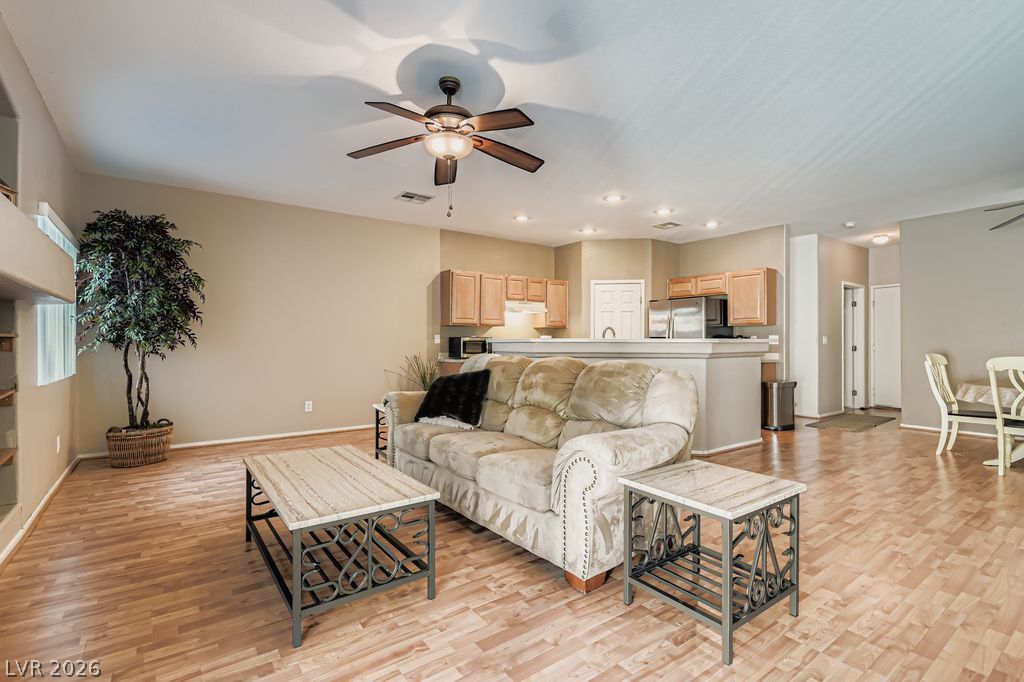 1586 Rusty Ridge Lane Henderson, NV 89002 - Photo 4 of 11 An inviting open-concept living area with a kitchen island and durable flooring, perfect for daily life.