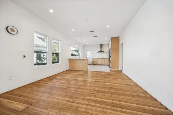 a view of empty room with kitchen and window