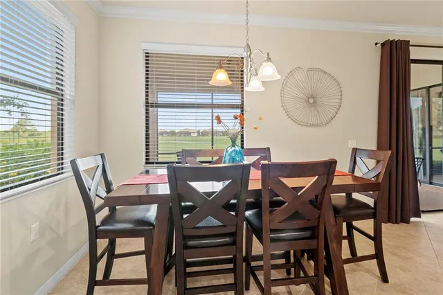 a kitchen with stainless steel appliances granite countertop a sink a stove a refrigerator cabinets and a dining table