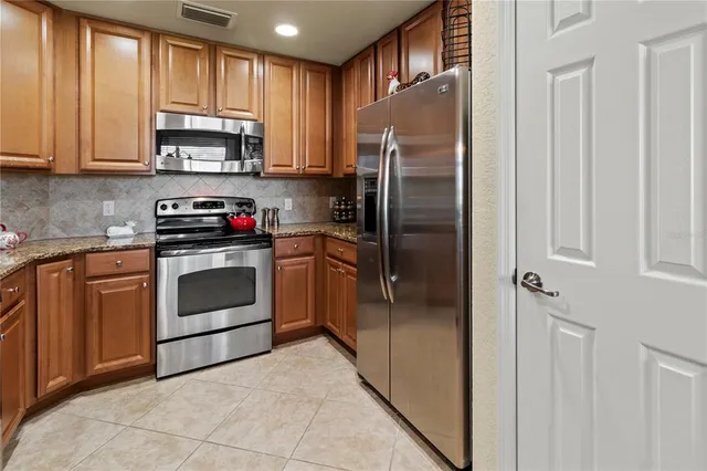 a kitchen with stainless steel appliances granite countertop a stove a sink and a dining table