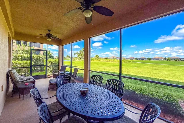 a living room with furniture and floor to ceiling windows