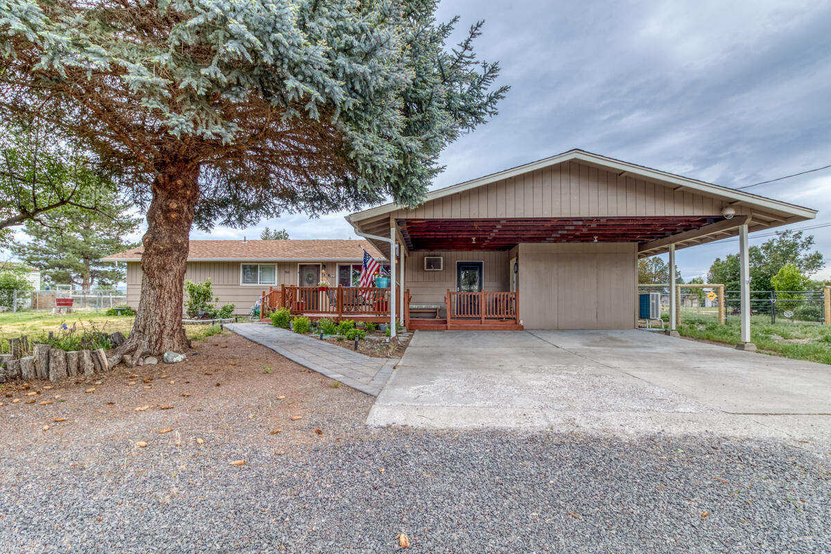 566 Northwest Mc Donald Road Prineville, OR 97754 - Photo 2 of 41 a view of a house with large tree and wooden fence