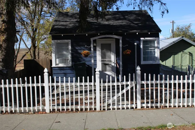 a view of a brick house with wooden fence