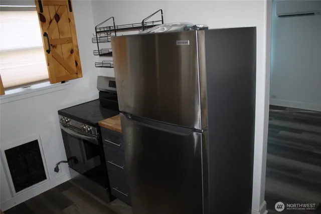 a metallic refrigerator freezer sitting in a kitchen