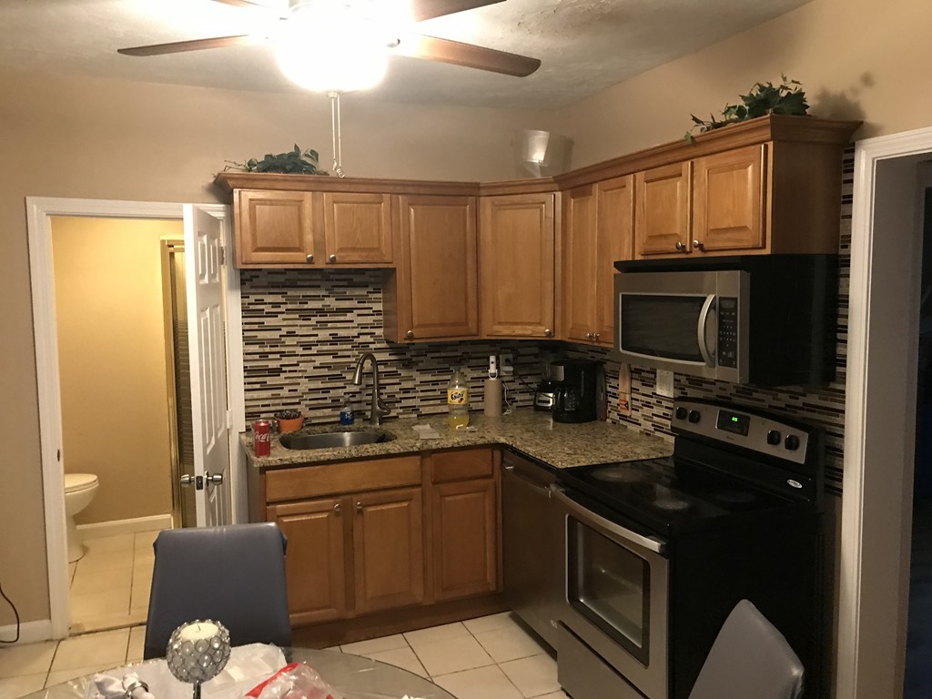 71 Birch Street Worcester, MA 01603 - Photo 16 of 23 a kitchen with stainless steel appliances granite countertop a stove a sink and a microwave