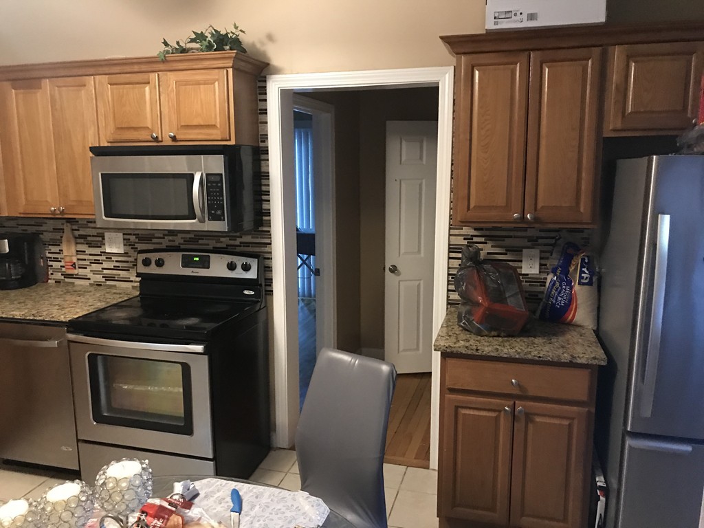 71 Birch Street Worcester, MA 01603 - Photo 17 of 23 a kitchen with stainless steel appliances granite countertop a stove microwave and refrigerator