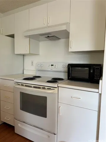 a kitchen with stainless steel appliances granite countertop white cabinets and a stove a oven with white countertops