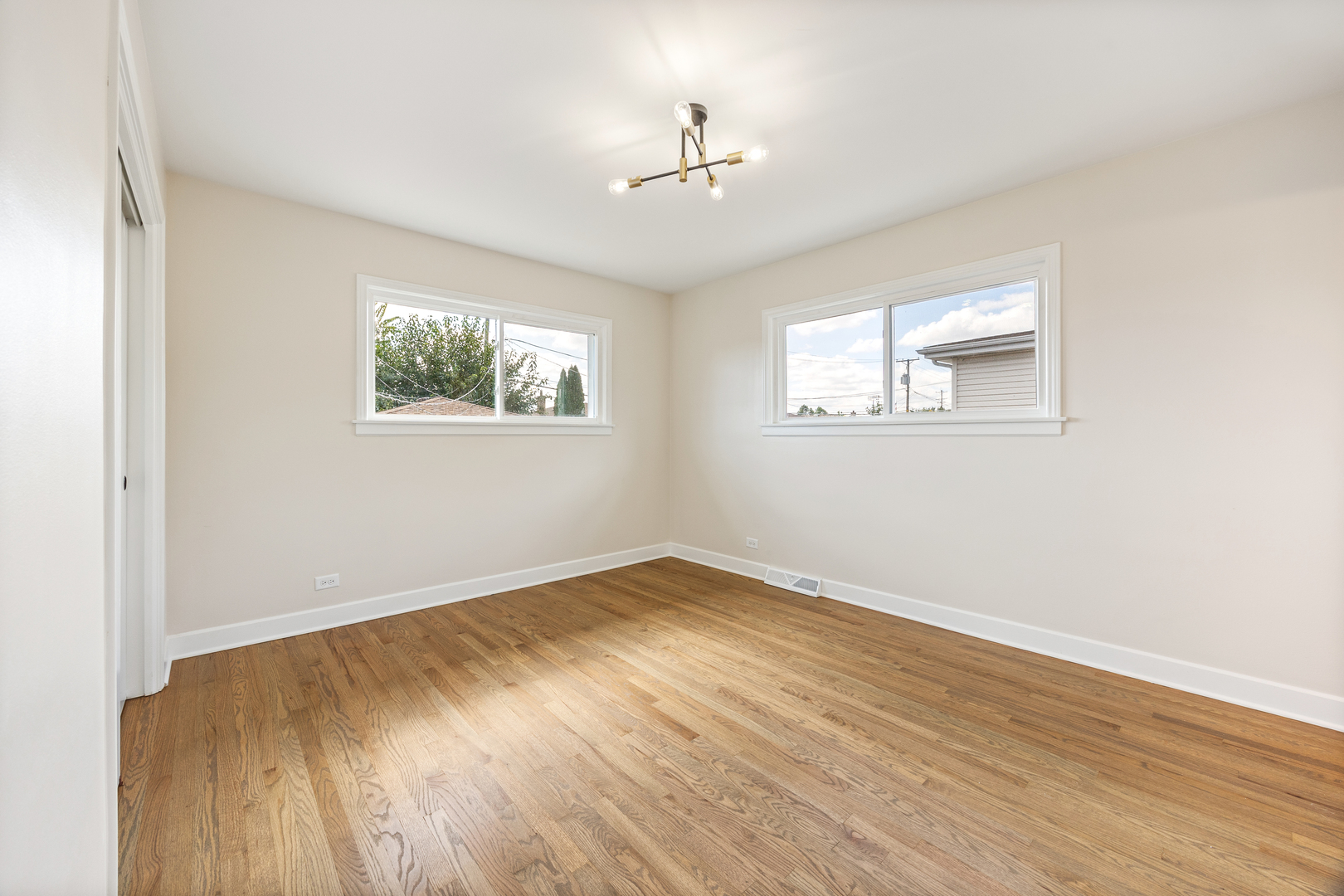 5821 Warren Street Morton Grove, IL 60053 - Photo 13 of 27 an empty room with wooden floor and windows