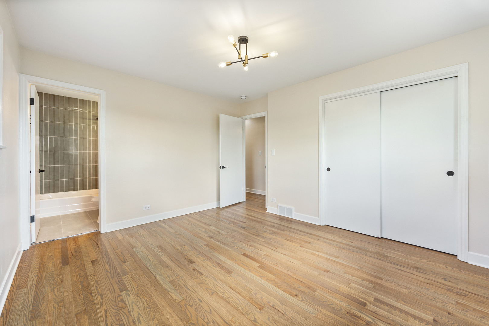 5821 Warren Street Morton Grove, IL 60053 - Photo 14 of 27 a view of an empty room with wooden floor and a ceiling fan