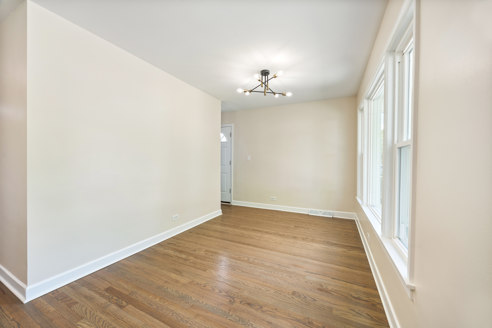 5821 Warren Street Morton Grove, IL 60053 - Photo 8 of 27 an empty room with wooden floor and chandelier fan