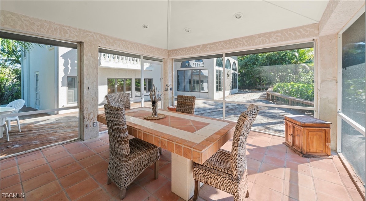 16632 Captiva Drive Captiva, FL 33924 - Photo 14 of 38 a view of a dining room with furniture large windows and wooden floor