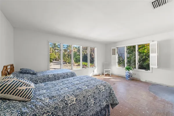 a bed sitting in a bedroom next to a window