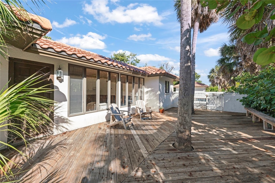 16632 Captiva Drive Captiva, FL 33924 - Photo 10 of 38 a view of a patio with table and chairs with wooden fence and floor