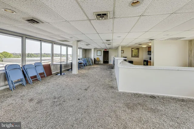 a large space with lots of table chair and chandelier