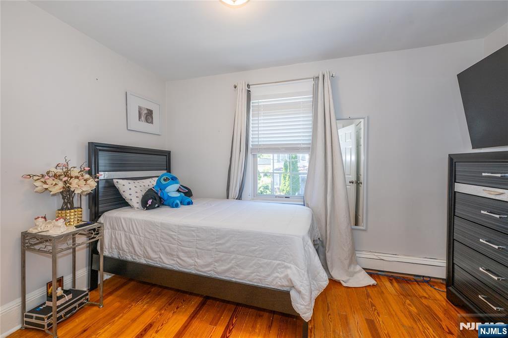 690 Garden Street Maywood, NJ 07607 - Photo 34 of 49 a bedroom with a bed and flat tv screen on the dresser