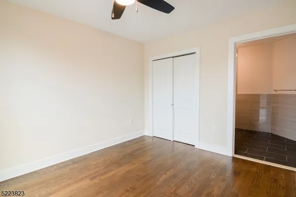 an empty room with wooden floor door and closet