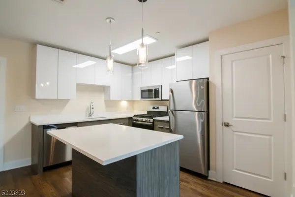 a kitchen with kitchen island a counter space and refrigerator