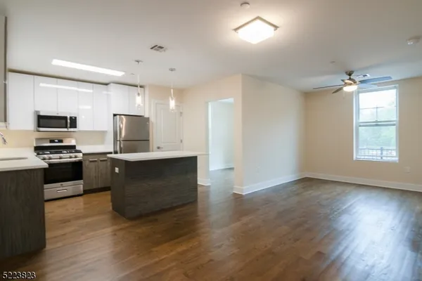 a kitchen with granite countertop a refrigerator and a stove top oven