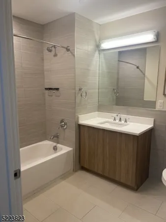 a bathroom with a bathtub a sink a mirror and a shower