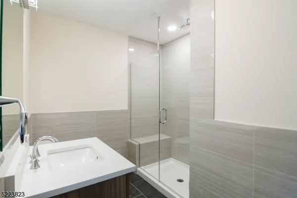 a bathroom with a sink shower and a mirror