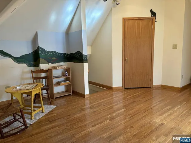 a view of a room with chairs and wooden floor