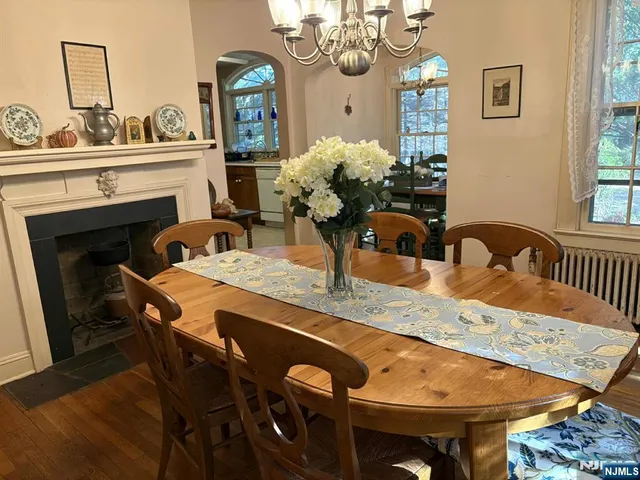 a dining room with furniture a fireplace and wooden floor