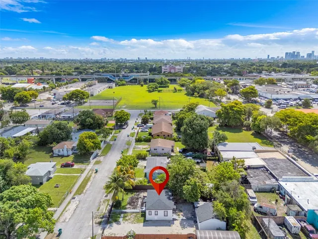 an aerial view of residential houses with outdoor space and pool